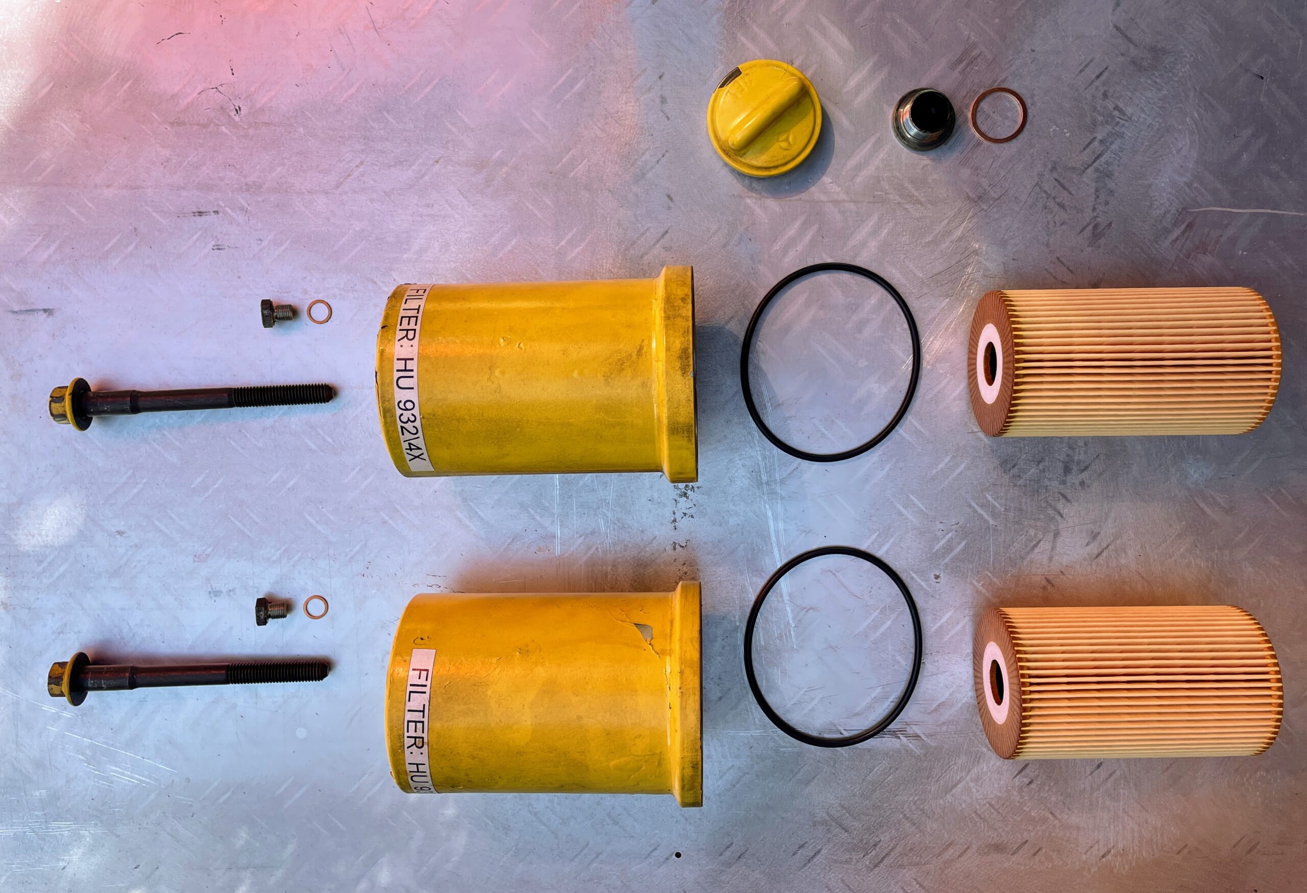 Exploded diagram-like photo of actual engine oil filters, canisters, and parts.